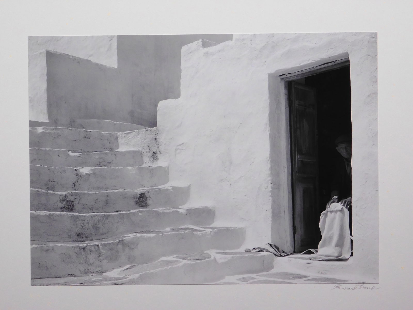 Howard Bond: Man in Doorway, Siphnos: Howard Bond (American, b. 1931): Man in Doorway, Siphnos. Silver gelatin print mounted to rag board, from portfolio VI Greek Islands, 1985, signed in pencil below. Edition 10 of 18. Howard Bond was a