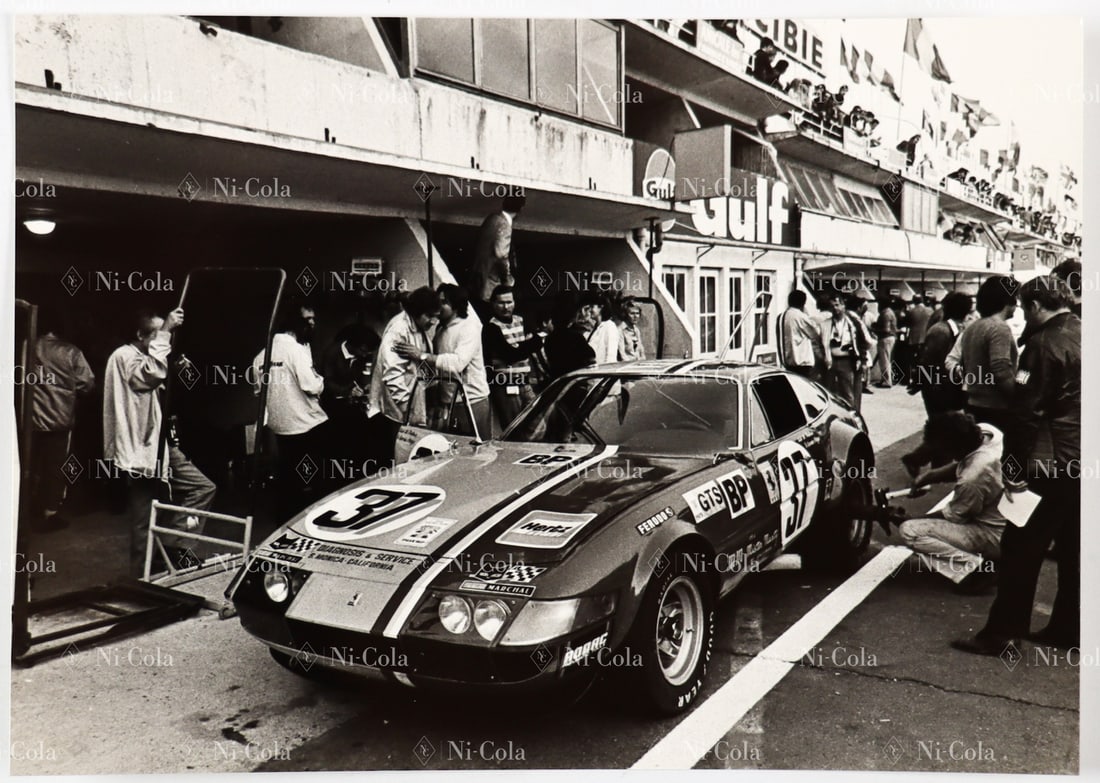 Ferrari Original B/W - Press photo 24h of Le Mans 1973: The 365 GTB/4 Daytona Competizione s/n 16367 by di Palma / Garcia - Veiga stands at the pit, 18 x 13 cm