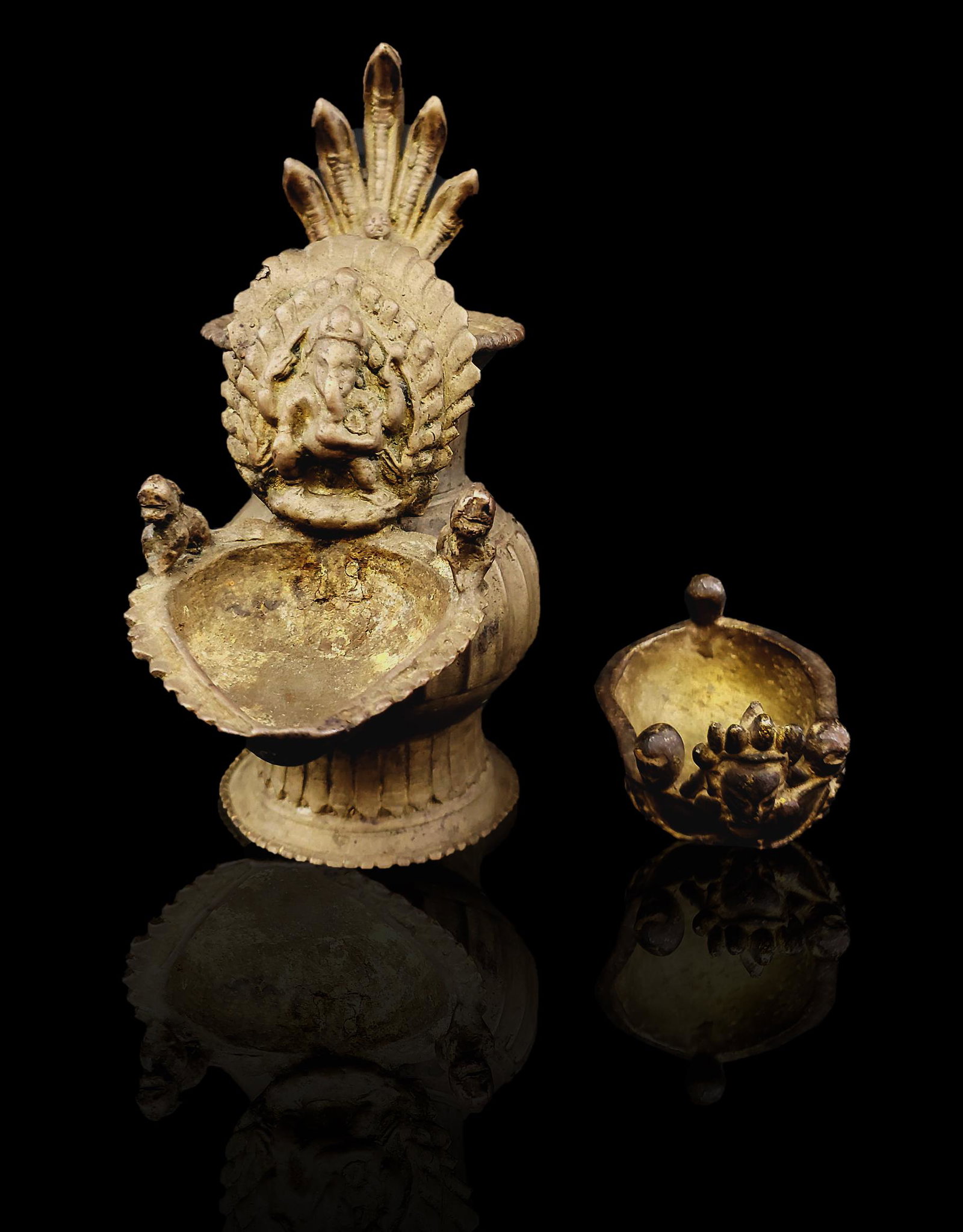 2 Nepalese Vessels oil lamps: Two Antique Nepalese Bronze Oil LampsCirca 1800. Featuring Vishnu and Ganesha. Handmade using the lost wax process where each individual piece is first made of beeswax then cast in clay for a mold. He
