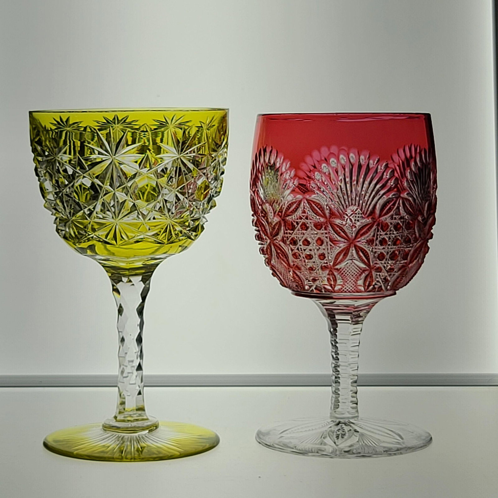 ABP Cut Glass Two wine stems, one cranberry cut to cle: ABP Cut Glass Two wine stems, one cranberry cut to clear (pattern unknown), one gold cut to clear in "Russian" pattern with a colored base.Measures 4 3/4" Each Stem.