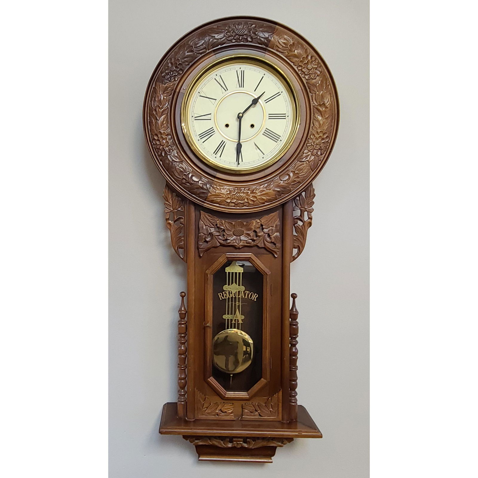 A Large Vintage Carved Regulator Wall Clock: A Large Carved Regulator Wall Clock. Measure 55" x 21 1/4". Finial need Re-dowelled and face needs a glass. Clock runs chimes but may need to be serviced.