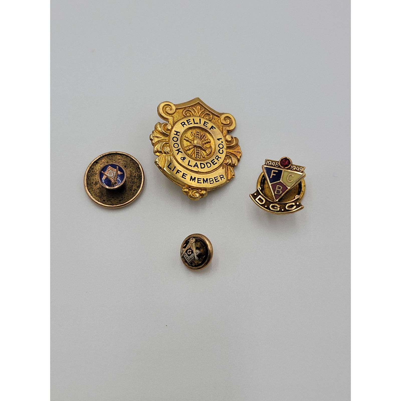Lot Of 4 10K Gold Pins Masonic And Hook & Ladder Co.1: Lot Of 4 10K Gold Pins Masonic And Hook & Ladder Co.1, 6.48 Grams Total.