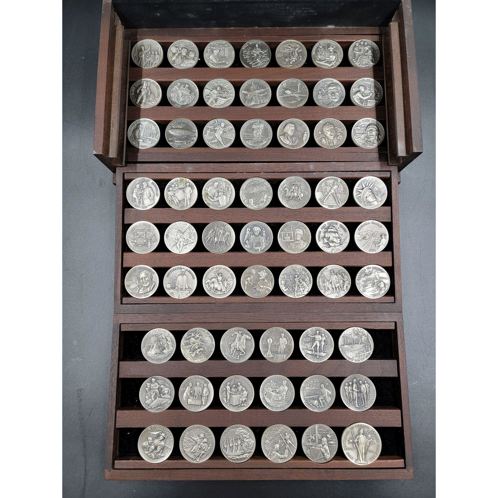 Longines Symphonette, (60) Sterling Medals 2050 Total G: Longines Symphonette, (54) sterling medals, "Great American Triumphs" set, each marked "Sterling" on the edge, approx. 40mm diameter except for last medal, 44mm diameter, in custom wood case with 3 tr