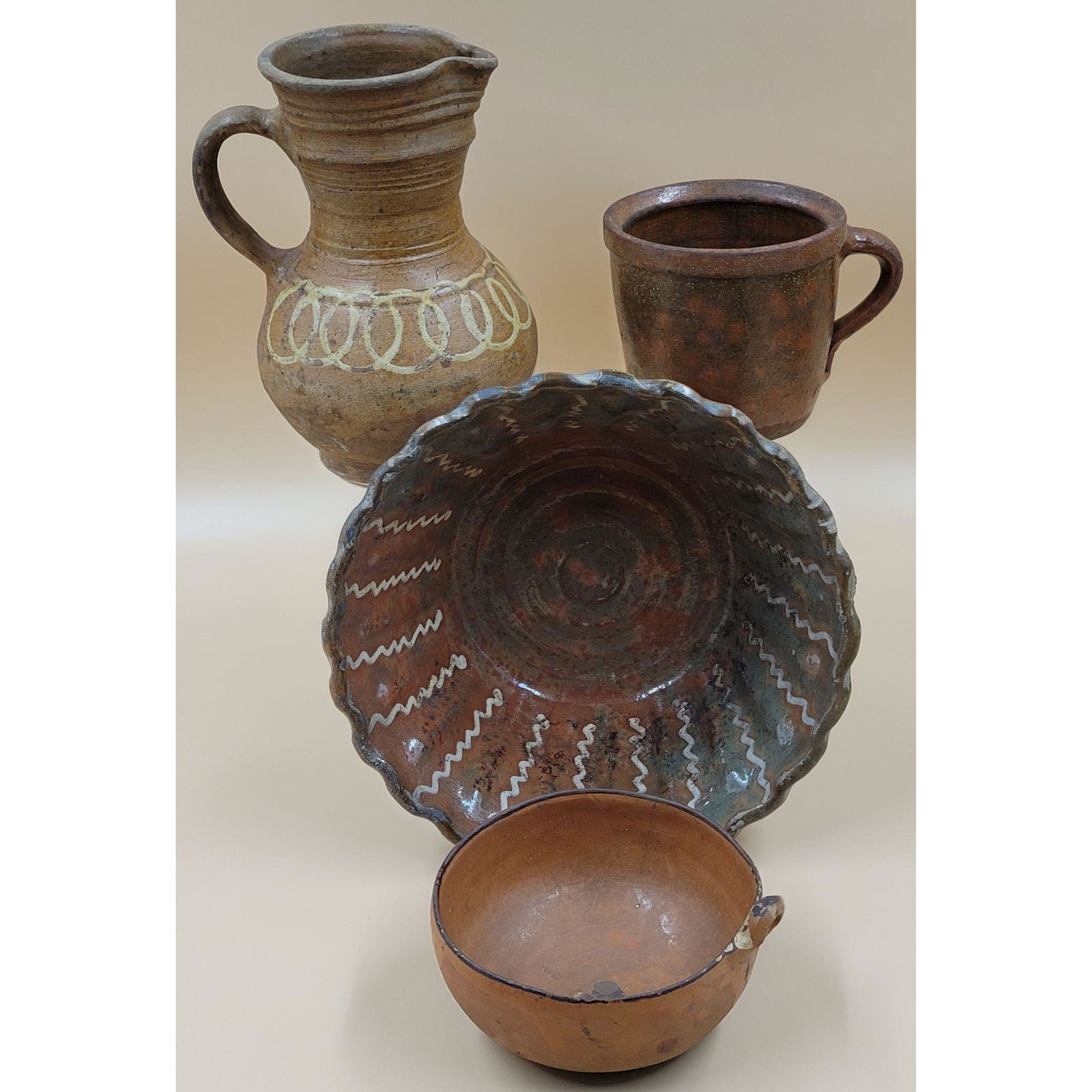A Lot of Four Antique Redware Pottery Pieces: A Redware collection comprised of various pottery types and sizes. This lot, and more forthcoming, are from the estate of a true antiquity connoisseur in every sense of the word. This antiquarian trul