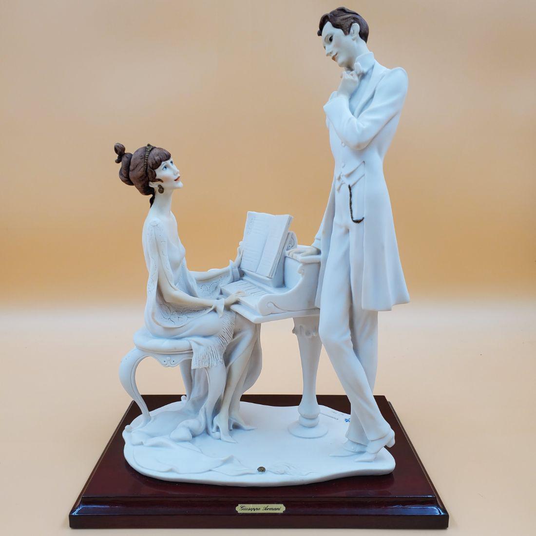 Giuseppe Armani Figurine: The Piano 443M: Giuseppe Armani Figurine: The Piano 443M. Depicts a couple around a piano. Measures 14 1/2" Tall. Please carefully read our terms of sale, shipping information, and request any condition reports or ph