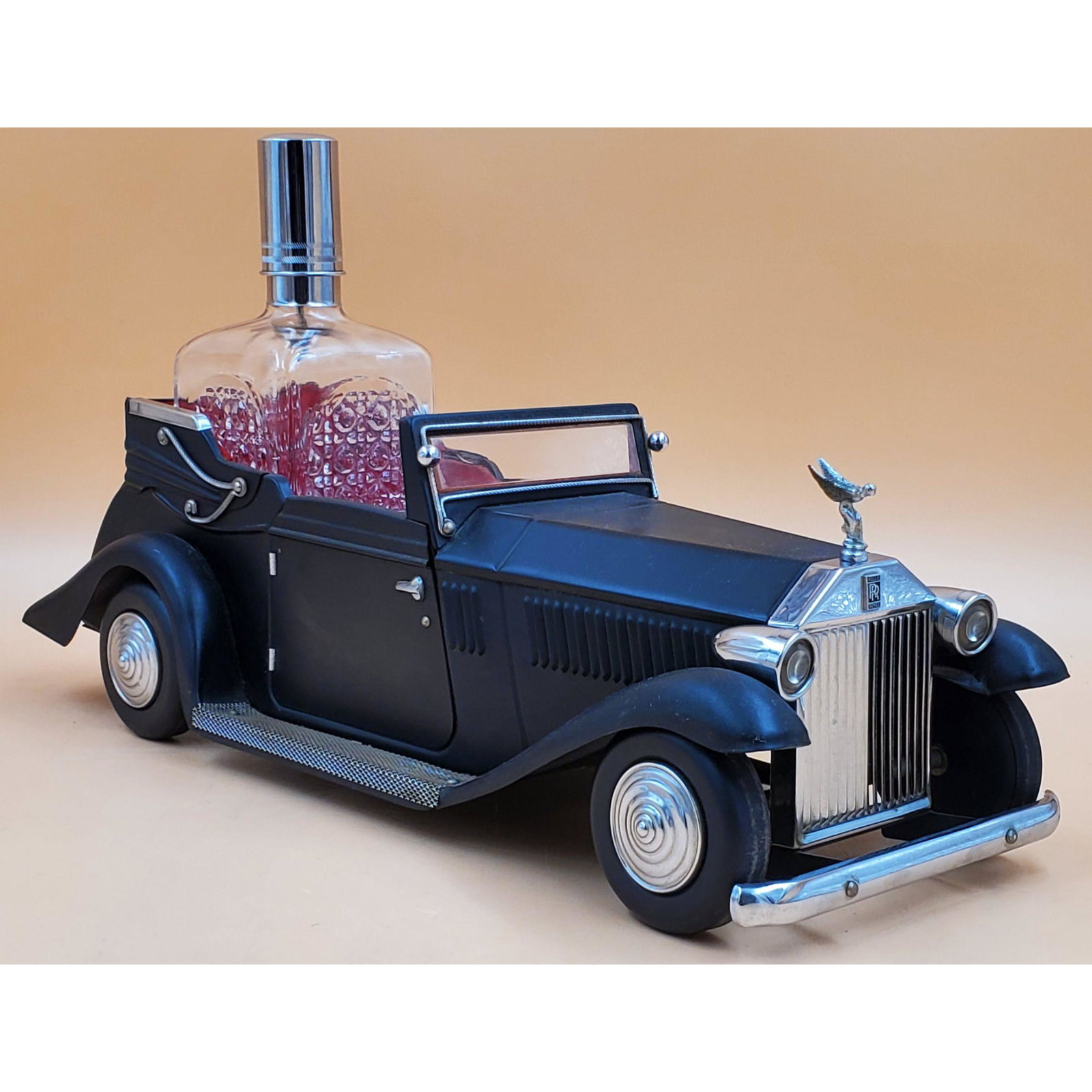 1950's Rolls Royce Musical Decanter and Shot Glasses Set: 1950's Rolls Royce Musical Decanter and Shot Glasses Set. It is missing one of its original shot glasses. Measures 16" x 6 1/4" x 9 1/8". Please carefully read our terms of sale, shipping information,