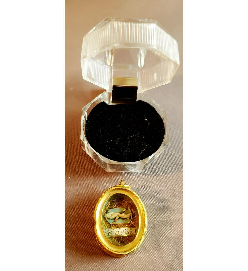 Relic Of Saint Francis of Assisi. Beautiful 2nd Class Relic: Relic of Saint Francis of Assisi. Beautiful 2nd class relic ( part of his clothing) in a gold oval theca. The theca is housed in a Gothic type hinged acrylic presentation case. Our most famous Saint p