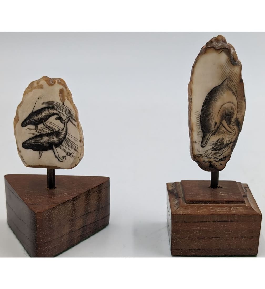 Pair Of Signed Ray Peters Engraved Scrimshaw On Wooden Stands: Pair Of Signed Ray Peters Engraved Scrimshaw On Wooden Stands. Measures approx. 2 1/2" and 3 1/2" tall. The shorter piece is signed but we believe both pieces are from the same artist. || Please caref