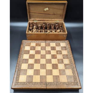 Hand Carved Chaku & Sons Walnut Folding Chessboard, Chess Pieces, And Storage Box: Hand Carved Chaku & Sons Walnut Folding Chessboard, Chess Pieces, And Storage Box. Box measures approx. 5 3/4" X 7 1/2" X 14", Chessboard measures approx. 1 1/2" X 17" X 17", and the pieces measure ap