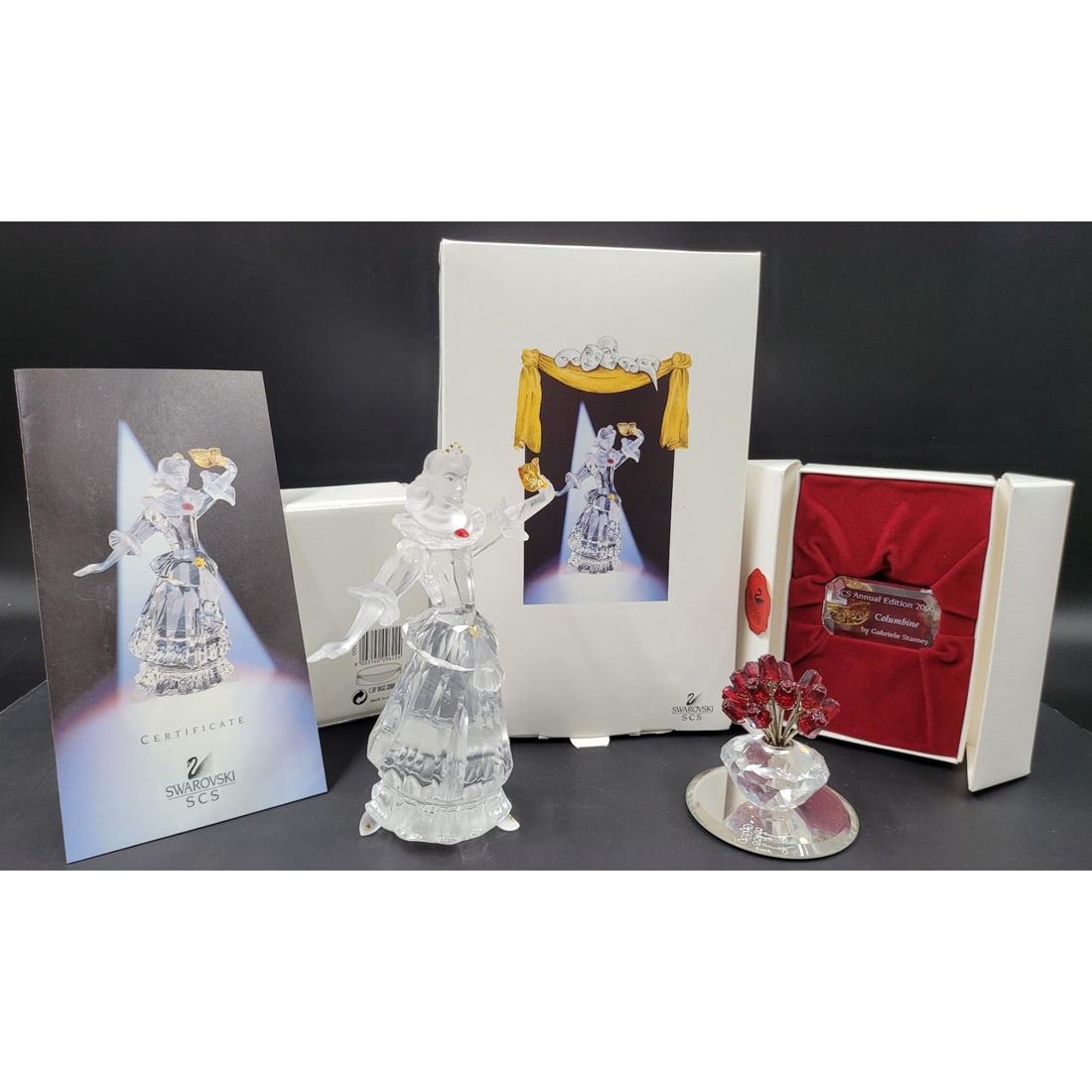Swarovski SCS Columbine Figurine & Plaque With Original Case And COA, With Vase Of Roses: Swarovski SCS Harlequin Figurine & Plaque With Original Case And COA, With Welcome Gift. Has Been previously repaired. Measures approx. 6.5" X 2.5" || Please carefully read our terms of sale, shipping