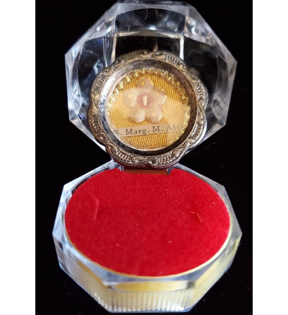 1st class relic of Saint Margaret Mary Alacoque: 1st class relic of Saint Margaret Mary Alacoque. The relic is contained in a fancy silver theca. The theca is housed in a Gothic type acrylic presentation case. Margaret Mary's body is incorrupt and b