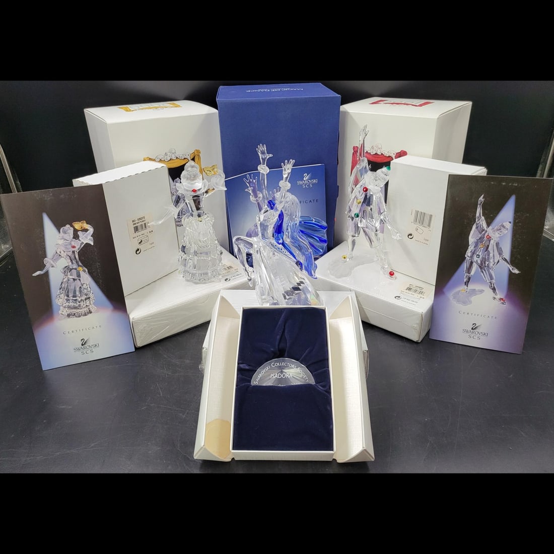 9 Piece Lot Of Swarovski SCS Figurines, Plaques, And Stands With COA: 9 Piece Lot Of Swarovski SCS Figurines, Plaques, And Stands With COA. Includes Isradora, Pierrot, and Columbine, each with plaques, stands, and COA. || Please carefully read our terms of sale, shippin