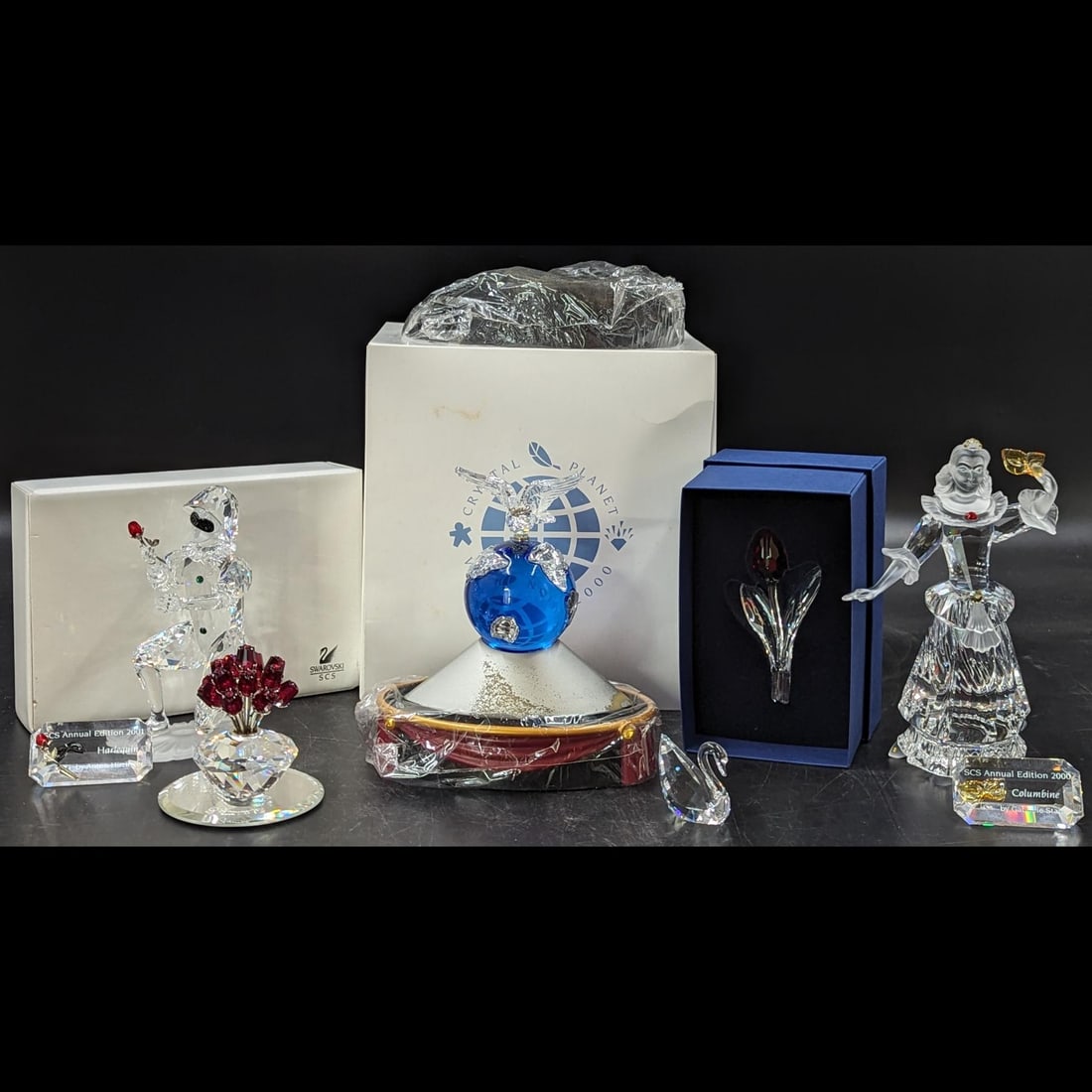 11 Piece Lot Of Swarovski SCS Figurines, Plaques, Stands, And Gifts: 12 Piece Lot Of Swarovski SCS Figurines, Plaques, Stands, And Gifts. Includes Harlequin, Columbine, and Crystal Planet; Harlequin And Columbine come with plaques and stands. || Please carefully read o