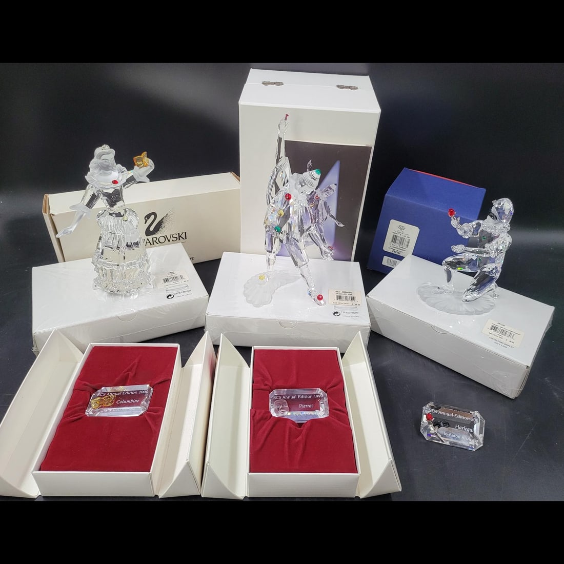 13 Piece Lot Of Swarovski SCS Figurines, Plaques, Stands, Gifts, and COA: 13 Piece Lot Of Swarovski SCS Figurines, Plaques, Stands, Gifts And COA. Includes Harlequin, Pierrot, and Columbine, each with plaques and stands. Lot includes 3 Gifts and 1 COA for Pierrot. || Please