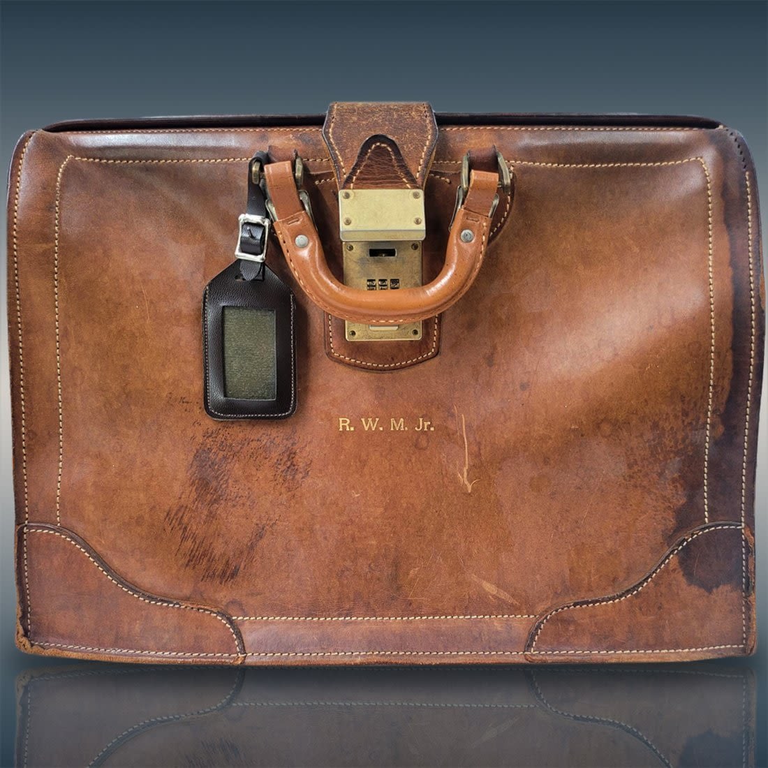 Vintage Leather Locking Leather Bag Briefcase: Vintage Leather Locking Leather Bag Briefcase. Combination to the lock is unknown. Bag Has scuffs from age and use, Please see pictures. Bag is engraved with initials R.W.M.Jr. Measures approx. 18" X 