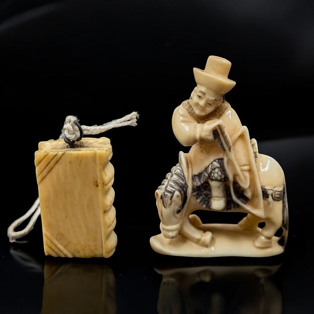 An Antique Finely Carved Signed Japanese Figure And A Finally Carved Book Pendant, 19th Century: An Antique Finely Carved Signed Japanese Figure And A Finally Carved Book Pendant, 19th Century. Measures approx. 2" X 1 1/4" and 1 1/4" X 1/2". Please copy and paste the URL link below to re