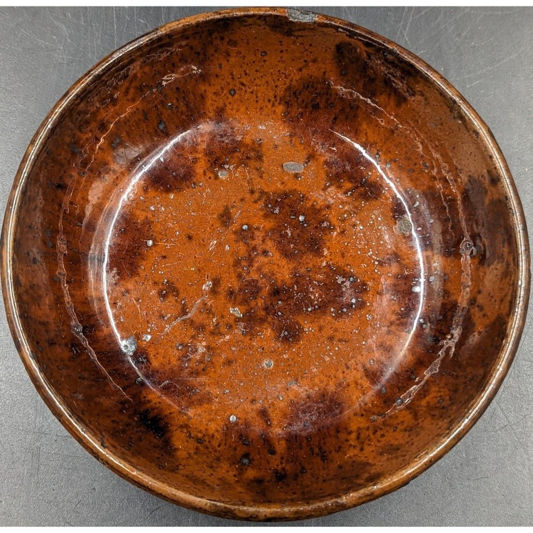 An Early Redware Pottery Bowl: An Early Redware Pottery Bowl. A fine glazed bowl, likely made in Pennsylvania at some time in the 18th/19th Century. Measures approx. 6 1/4" in diameter and 1 1/2" deep. Please copy and past