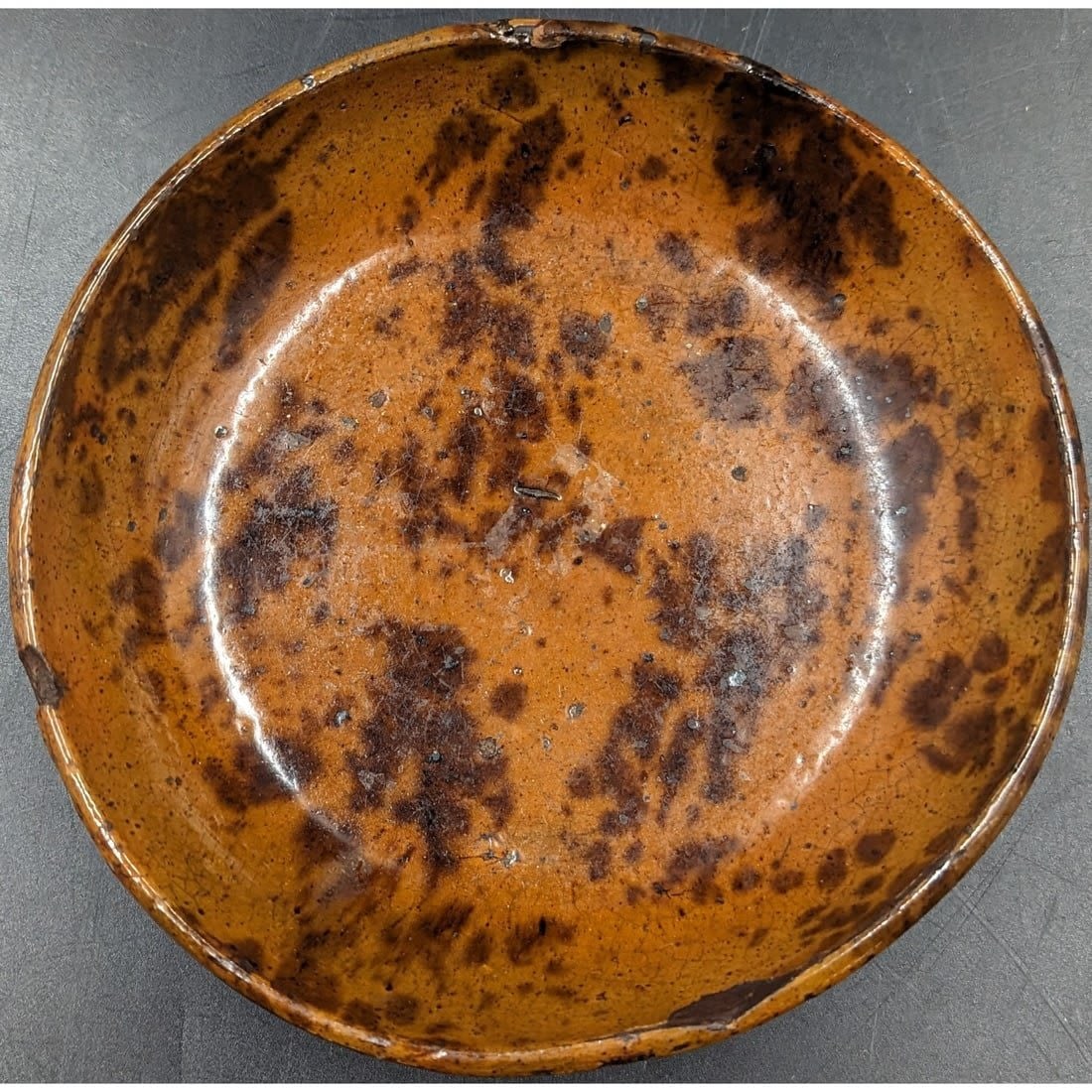 An Early Redware Pottery Bowl: An Early Redware Pottery Bowl. A fine glazed bowl, likely made in Pennsylvania at some time in the 18th/19th Century. Measures approx. 7" in diameter and 1 1/4" deep. Please copy and paste th