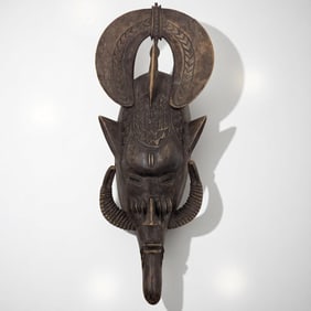 A Carved Wood African Senufo Mask With Protruding Horns And Bird Atop The Head