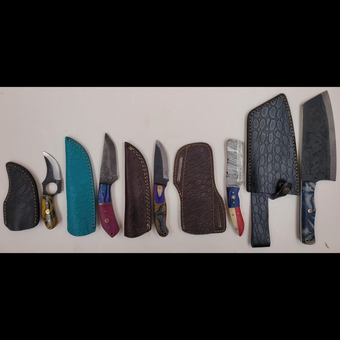 5Pc Hand Made Damascus Steel Knives And Sheaths: **DUE TO THIS LOT BEING CLASSED AS A WEAPON IT MUST BE PAID VIA BANK WIRE TRANSFER OR CERTIFIED CHECK.** 5Pc Hand Made Damascus Steel Knives And Sheaths. knives measure approx. 12" X 3", 8" X 1.25", 8