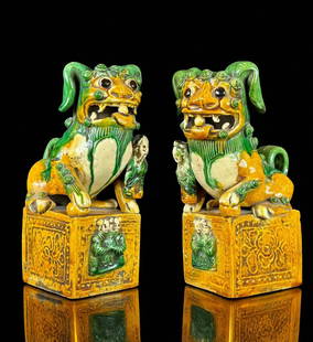 Pair of Chinese unique formed and whimsical standing pottery fu dogs / sancai foo lions: Pair of Chinese unique formed and whimsical standing pottery fu dogs dating from the Ming dynasty or earlier. Decorated with acolytes atop a square form relic worked pedestal. Glazed in a marvelously