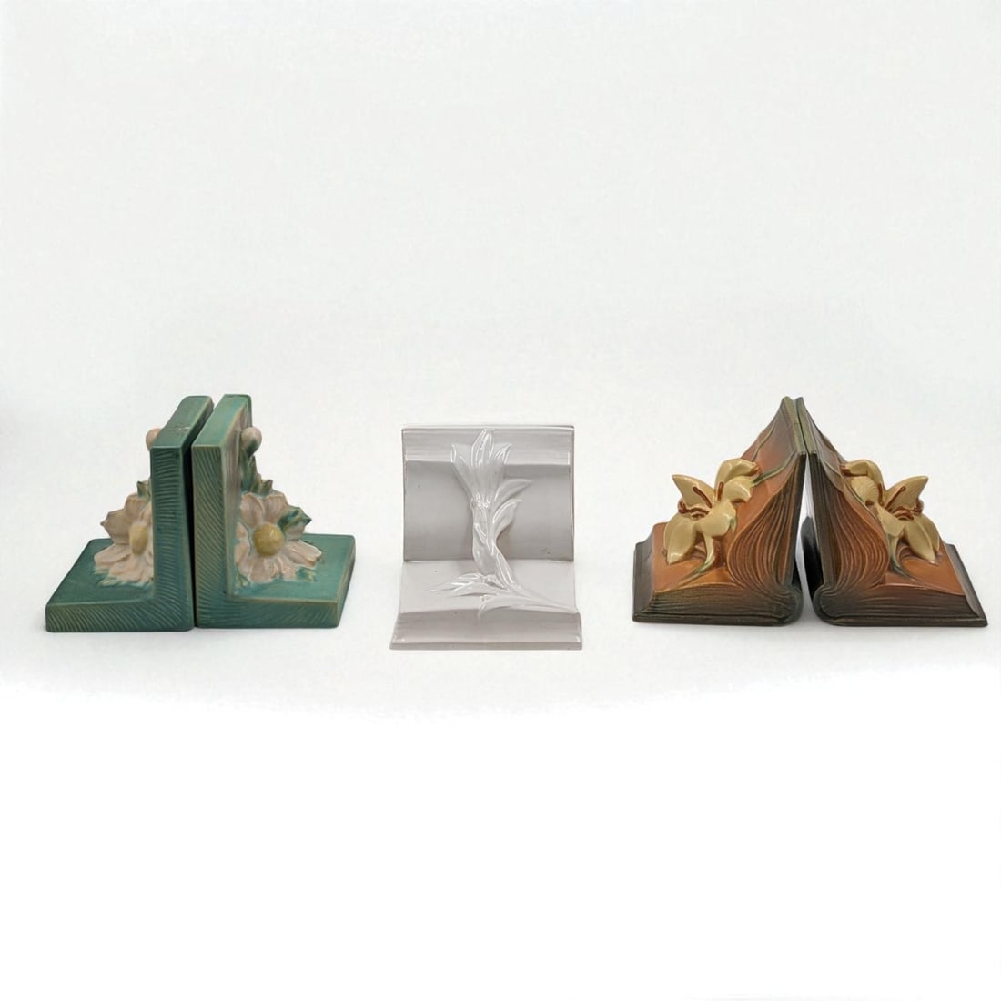 Lot Of 3 Vintage Roseville Pottery Bookend Pairs: Lot Of 3 Vintage Roseville Pottery Bookend Pairs. Includes Brown Zephyr Lily Bookends, Green Magnolia Bookends, And Ivory II Velmoss Bookends. Measures approx. 5 1/4" X 5" X 5 1/4", 4 1/2" X 4" X 5 1/