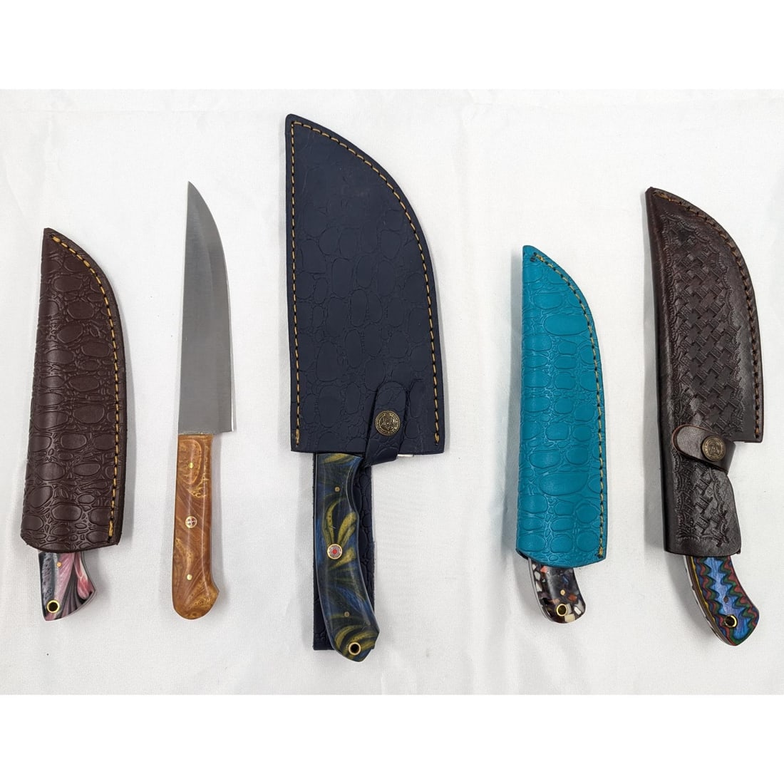 5Pc Hand Made Damascus Steel Knives And Sheathes: **DUE TO THIS LOT BEING CLASSED AS A WEAPON IT MUST BE PAID VIA BANK WIRE TRANSFER OR CERTIFIED CHECK.** 5Pc Hand Made Damascus Steel Knives And Sheathes. Knives measure 8 1/2", 8 3/4", 10", 10 1/2", 