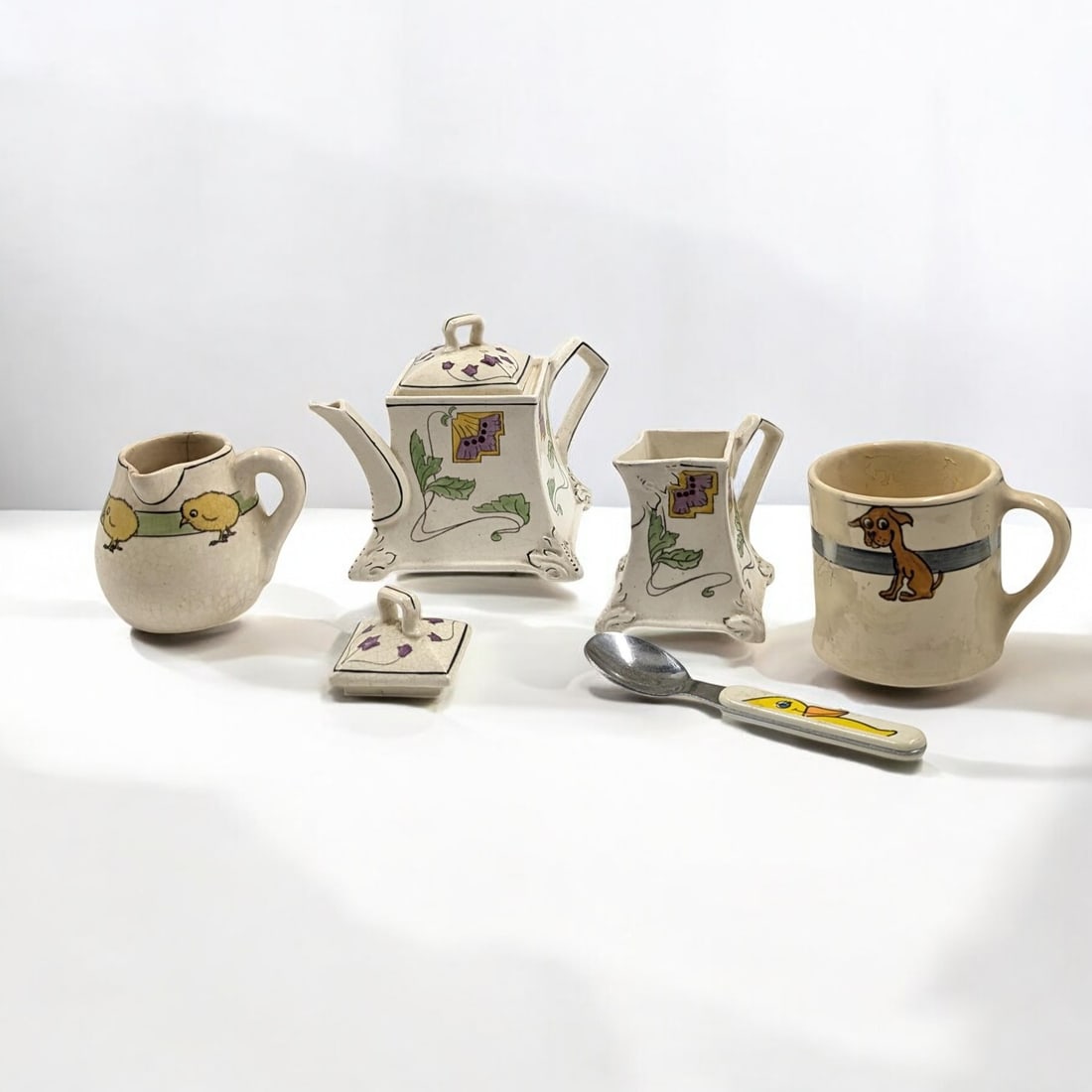 Lot Of 6 Antique / Vintage Roseville Creamware Pottery Pieces: Lot Of 6 Antique / Vintage Roseville Creamware Pottery Pieces. Includes a Donatello Persian Chocolate Pot, Creamer, And Lid and Juvenile Creamware Creamer, Mug, And Spoon. Measures approx. 3" X 3 1/2"