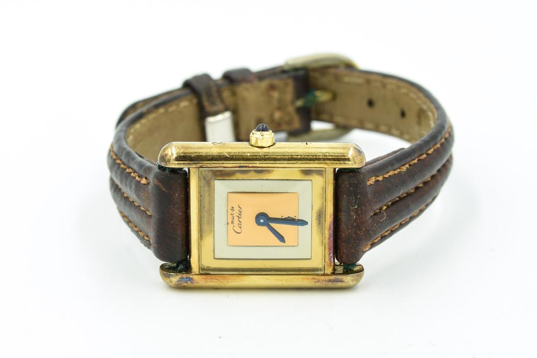 Ladies Must De Cartier Tank Vermile Gold / Silver: The watch features a rectangular tank with a sterling silver gold electroplated case measuring 27.50mm x 22.50mm including the crown (Ref 19560 Serial # 366001). The watch is attached to a brown leath