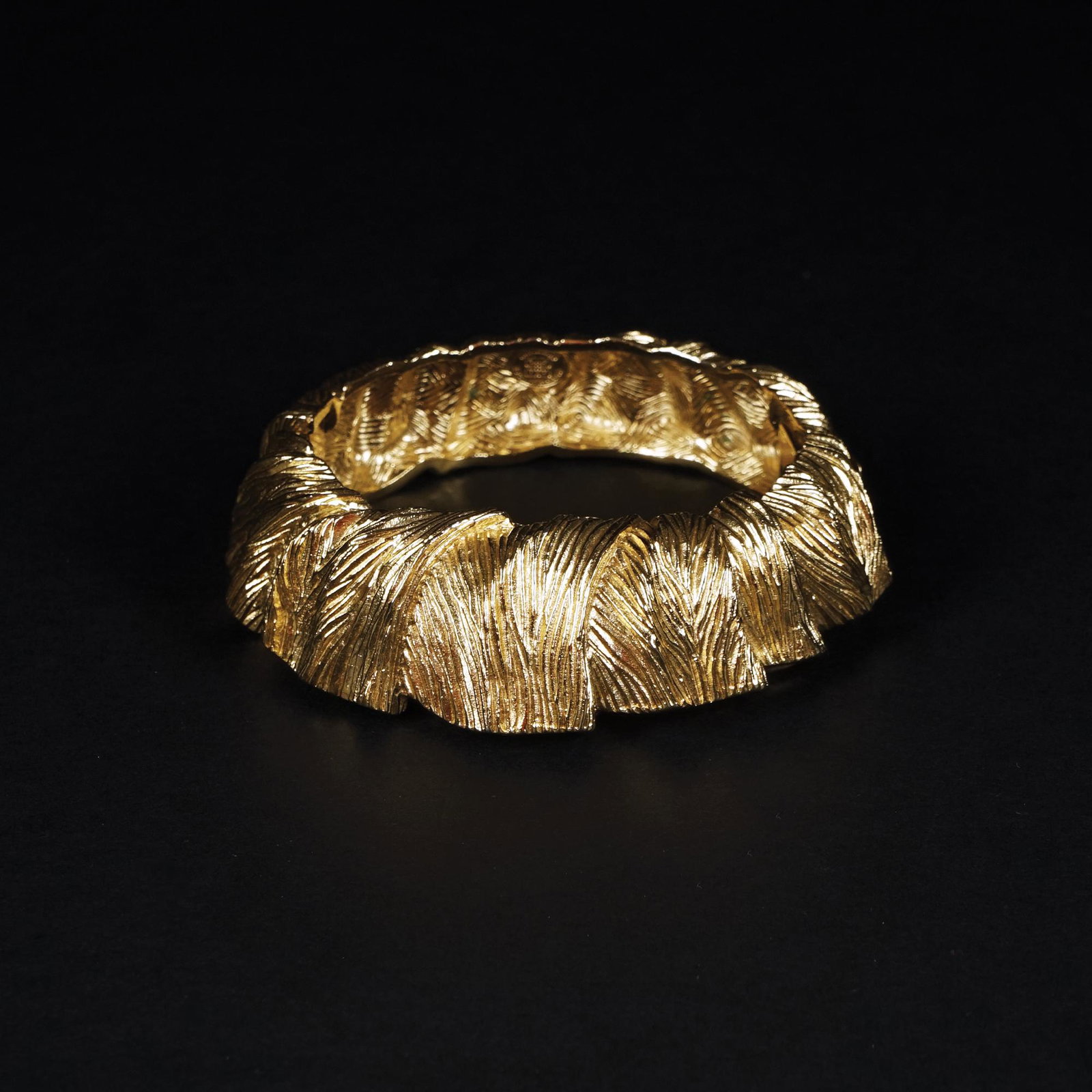 Givenchy: a gilt metal rigid bracelet with leaf motifs, 5by6cm.