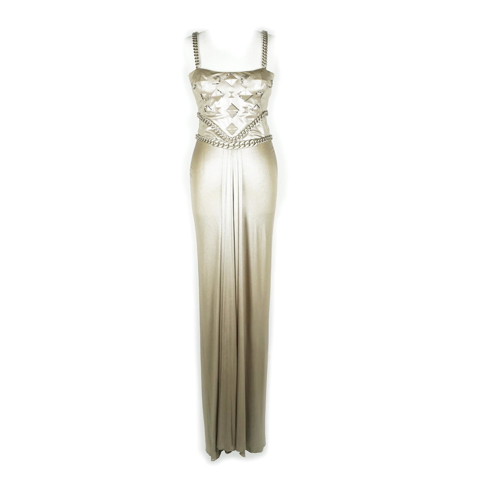 Versace: a long dress in beige silver jersey with chain straps; the same motif enriches the waist