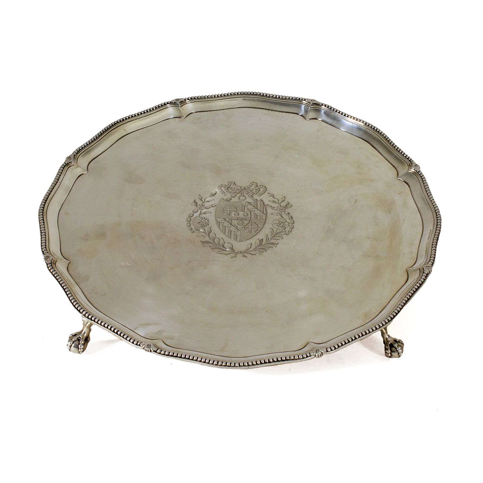 Salver in sterling silver, London, 1780, Daniel Smith & Robert Sharp: circular in shape with a beaded motif chiselled edge profile; cavetto centered by an engraved coat of arms; four small paws of a bird of prey holding a sphere, d. cm. 41, weight gr. 1,902