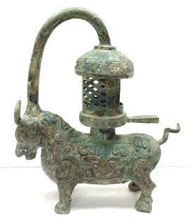 A large antique bronze censer in the Chinese archaic style in the shape of a bull with a curved: A large antique bronze censer in the Chinese archaic style in the shape of a bull with a curved handle and a censer/lantern cone. Height 40 cm.
