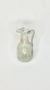 Ancient Roman Glass Juglet 4th Century BC: Title/Medium: Ancient Roman Glass Juglet Origin/Year: Rome, 4th Century BC Dimensions: Height 11.7 cm Condition: Good, with signs of age and iridescent patina Provenance: Archaeological artifact Ad