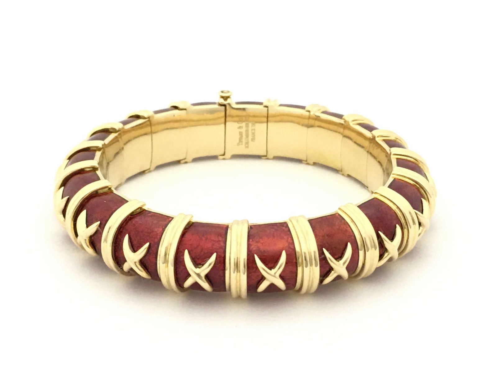 Tiffany & Co. Schlumberger Vintage Croisillon Red Enamel 18K Yellow Gold Bracelet: Striking Tiffany & Co. bracelet designed by Jean Schlumberger, crafted in solid 18K yellow gold with rich red enamel panels. The iconic Croisillon design features repeating gold cross motifs over the