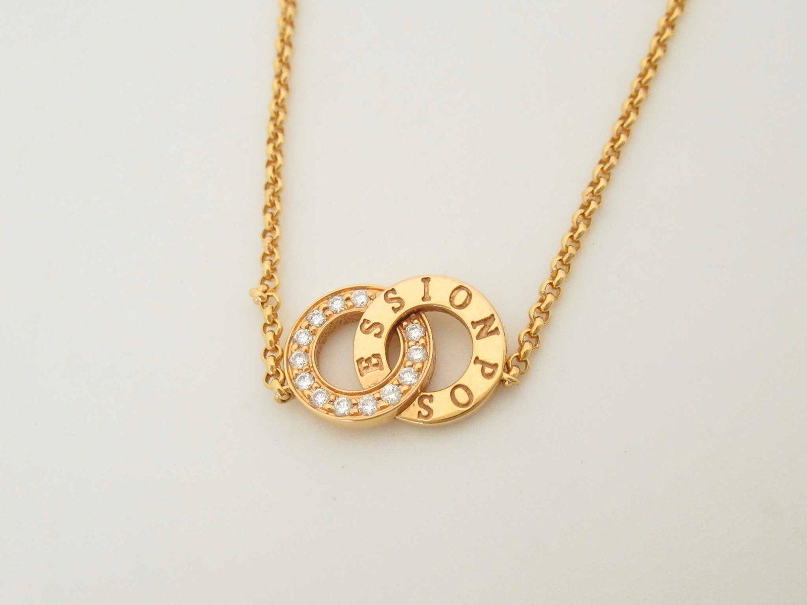 Piaget Possession Diamond 18K Yellow Gold Necklace: Elegant Piaget Possession necklace crafted in solid 18K yellow gold featuring the Maison's iconic rotating ring motif accented with brilliant diamonds. The interlocking circular design symbolizes move