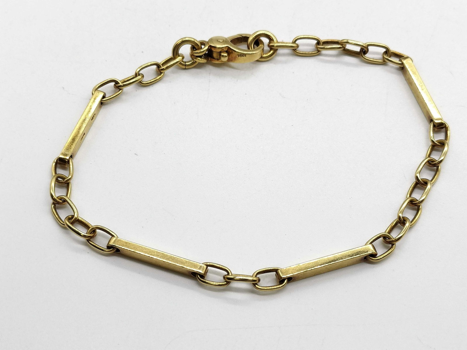 Pomellato Link Bracelet 18K Yellow Gold: Elegant Pomellato bracelet crafted in solid 18K yellow gold, featuring a distinctive link design combining elongated bar elements with classic oval chain links. The minimalist yet sculptural compositi