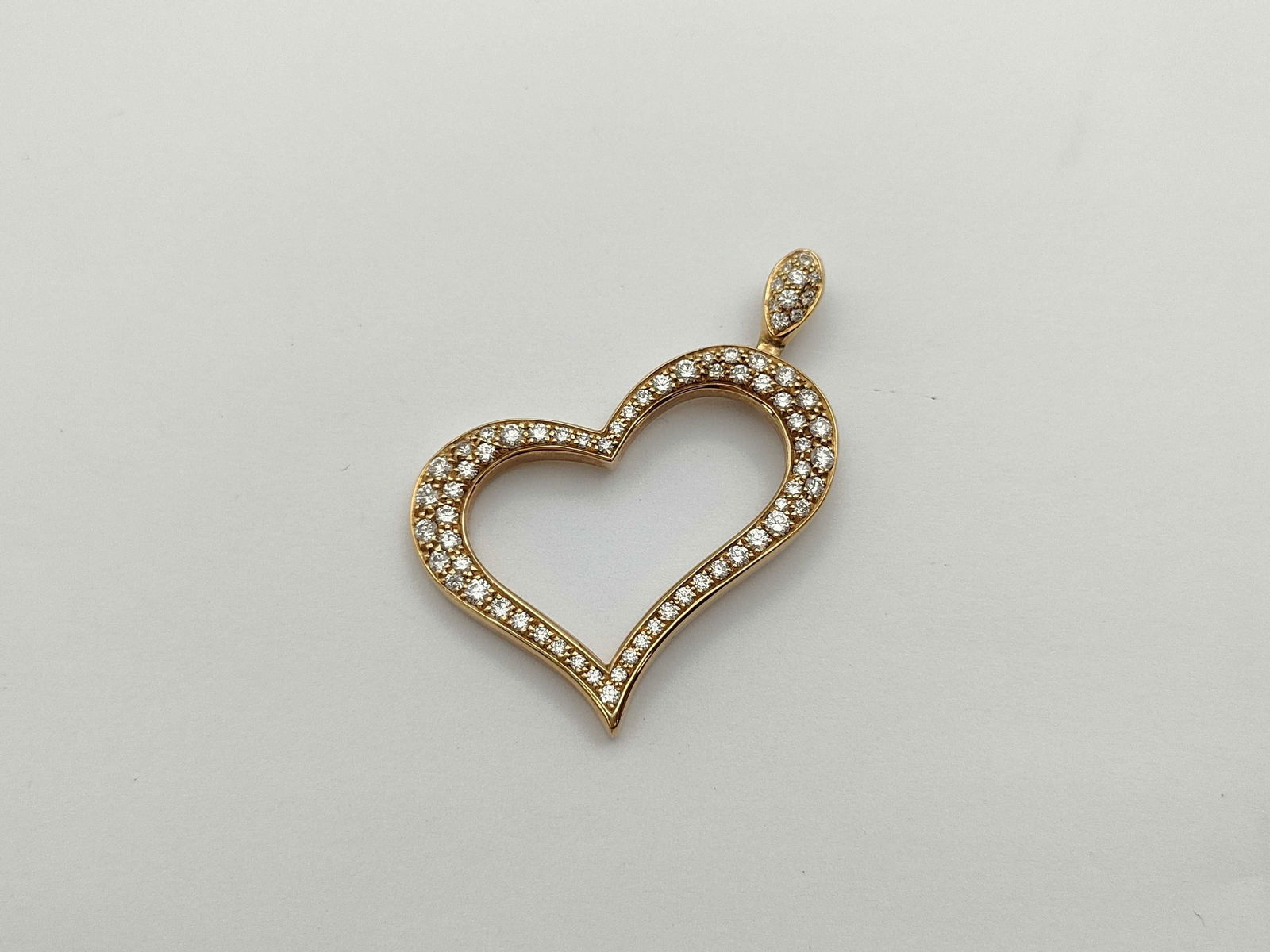 Piaget Diamond Heart 18K Yellow Gold Pendant: Elegant Piaget heart pendant crafted in solid 18K yellow gold and set throughout with brilliant pave diamonds. The open heart silhouette is enhanced by a diamond-set bail, creating a refined and lumin
