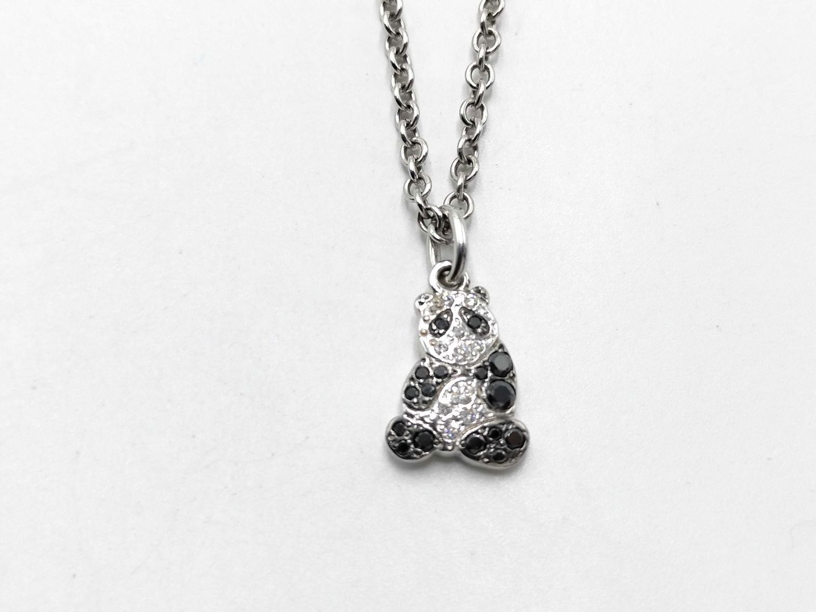 Pomellato Panda Motif Diamond & Black Diamond 18K White Gold Necklace: Charming Pomellato panda motif necklace crafted in solid 18K white gold, set with sparkling white diamonds and contrasting black diamonds forming the playful panda design. The pendant hangs from a del
