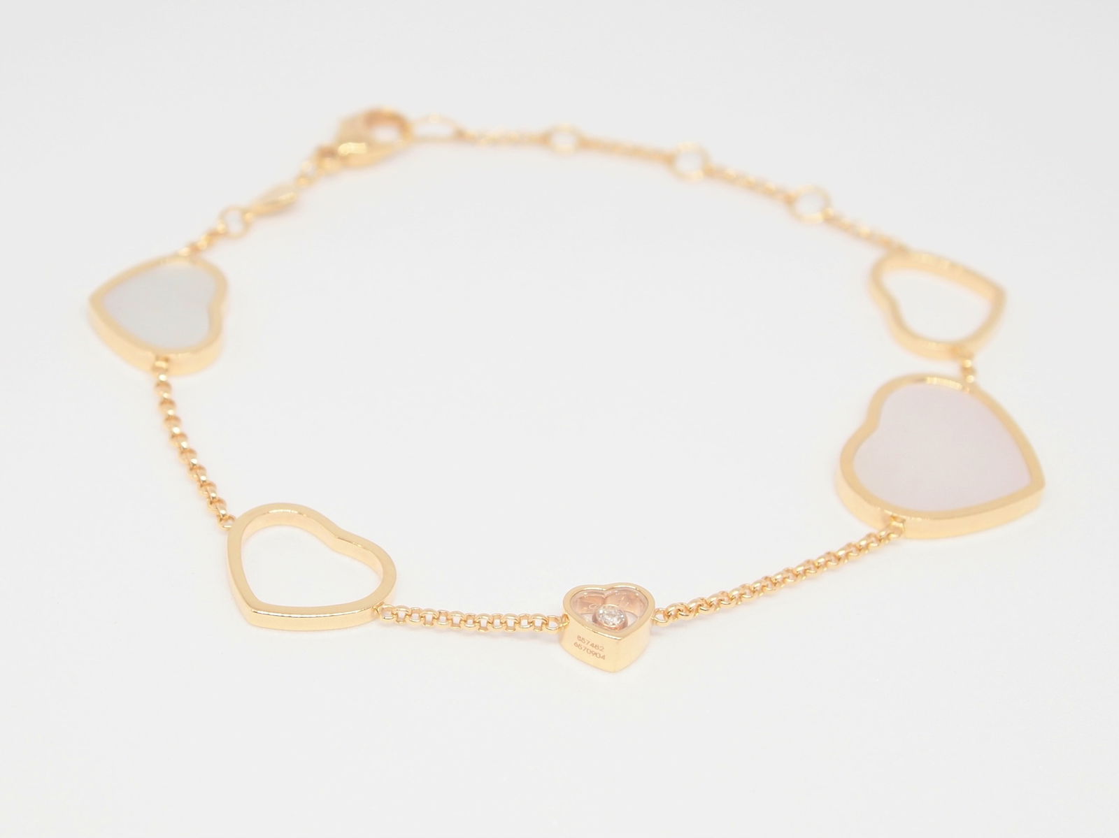 Chopard Happy Hearts Mother of Pearl Floating Diamond 18K Rose Gold Bracelet: Description: Iconic Chopard Happy Hearts bracelet crafted in solid 18K gold, featuring elegant heart motifs including luminous mother-of-pearl and the collection?s signature floating diamond element e