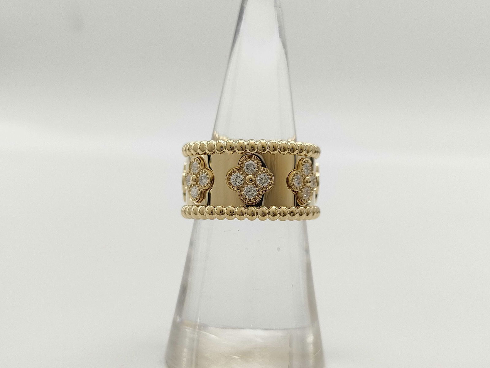 Van Cleef & Arpels Perlee Diamond Clover 18K Yellow Gold Ring: This elegant Van Cleef & Arpels Perlee Sweet Clover bangle bracelet is crafted in solid 18K gold and features the signature clover motif accented with brilliant diamonds. The refined design showcases