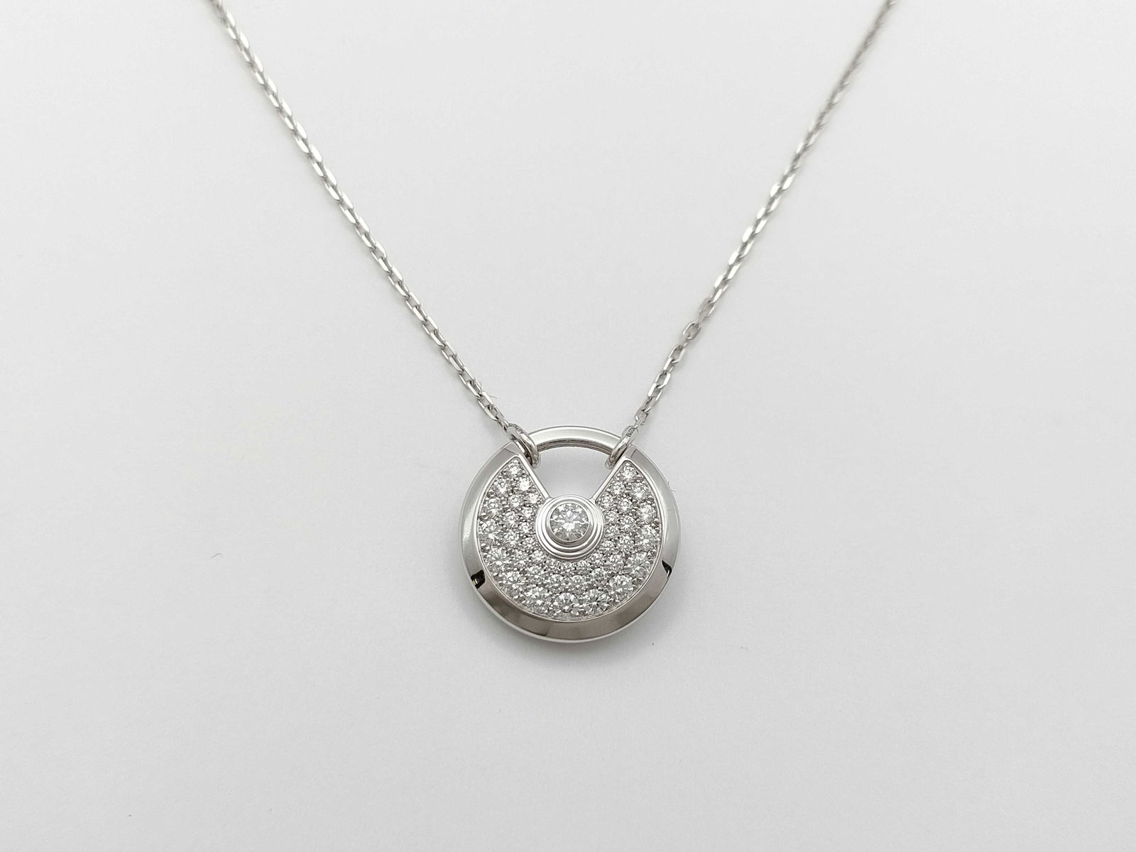 Cartier Amulette Diamond Pave Large 18K White Gold Pendant Necklace: Description: This elegant Amulette de Cartier Large pendant necklace is crafted in solid 18K white gold and features brilliant pave-set diamonds within the collection?s iconic circular design. The ref