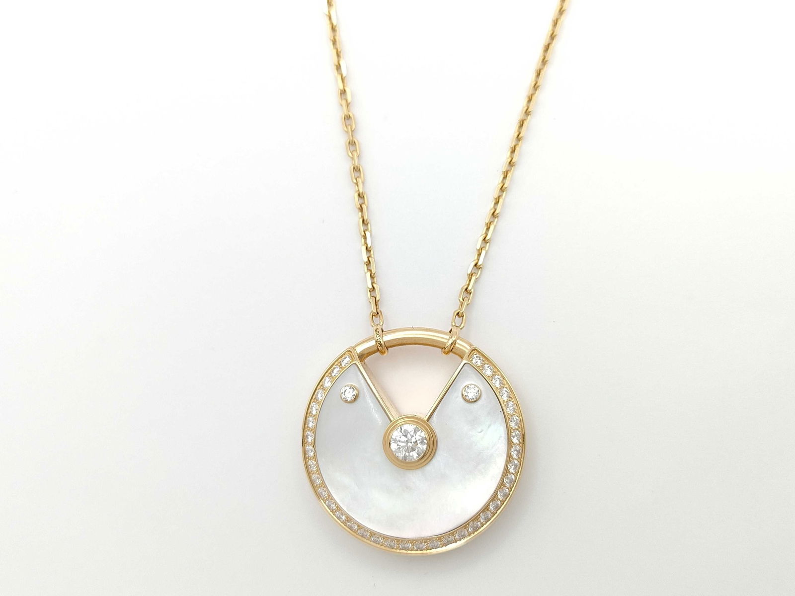 Cartier Amulette Large Mother of Pearl Diamond 18K Yellow Gold Pendant Necklace: Description: This elegant Amulette de Cartier Large pendant necklace is crafted in solid 18K yellow gold and features luminous white mother-of-pearl accented by a brilliant diamond within the collecti