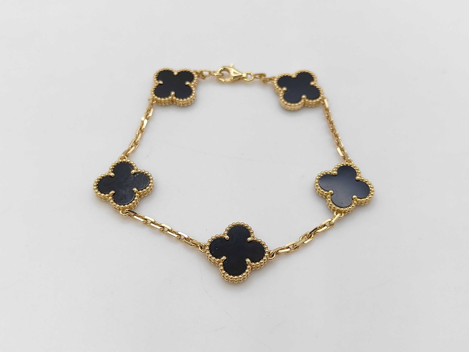 Van Cleef & Arpels Vintage Alhambra Black Onyx 5 Motif 18K Yellow Gold Bracelet: Description:Elegant Van Cleef and Arpels Vintage Alhambra bracelet crafted in 18K gold and featuring five iconic clover motifs set with deep black onyx. The smooth polished surface of the onyx contras