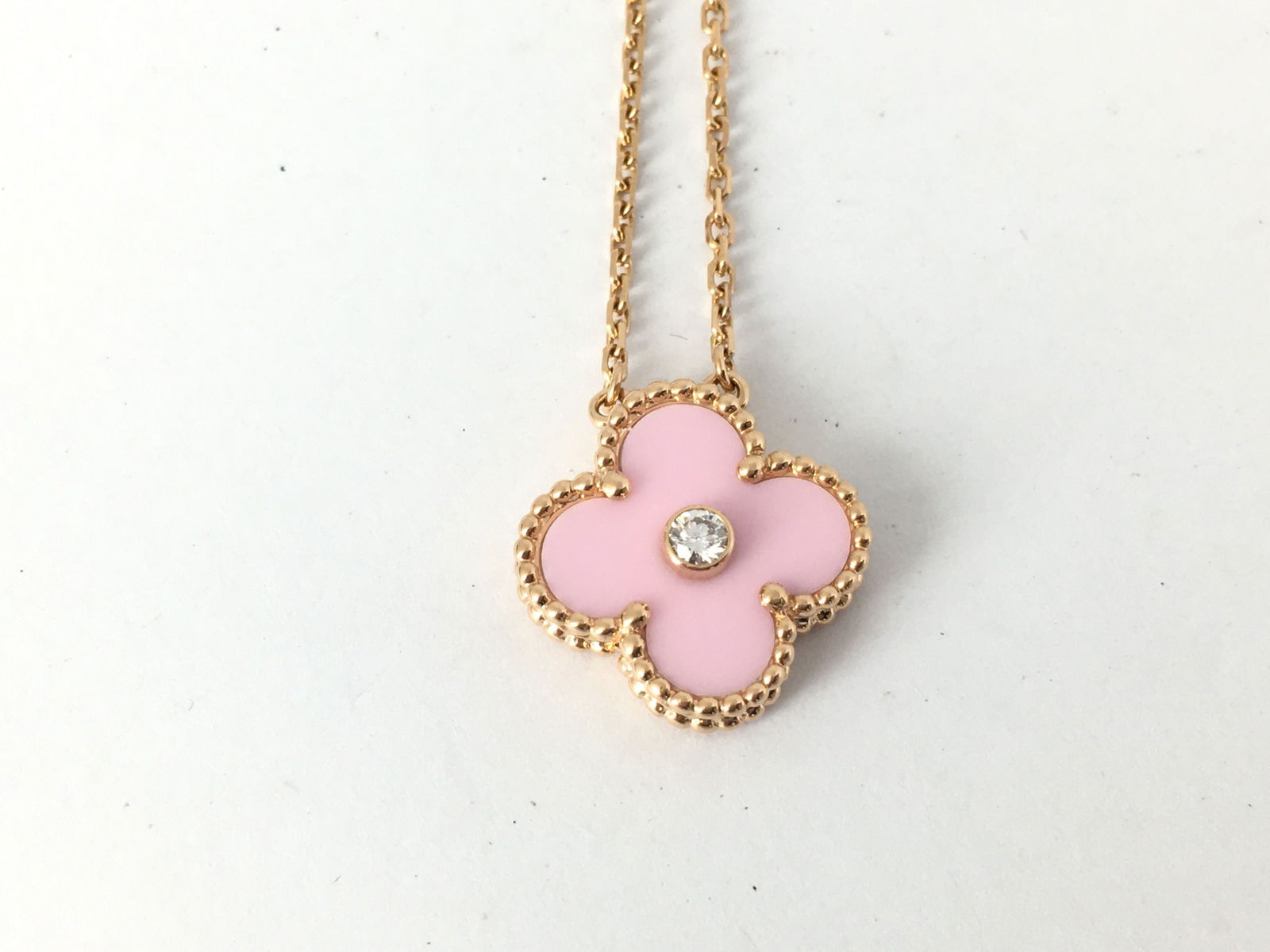 Van Cleef and Arpels Vintage Alhambra Holiday Edition 2015 Pink Ceramic Diamond 18K Gold Pendant: Description:Elegant Van Cleef and Arpels Vintage Alhambra Holiday Edition 2015 pendant necklace crafted in 18K rose gold and featuring a single iconic Alhambra motif set with pink ceramic and accented