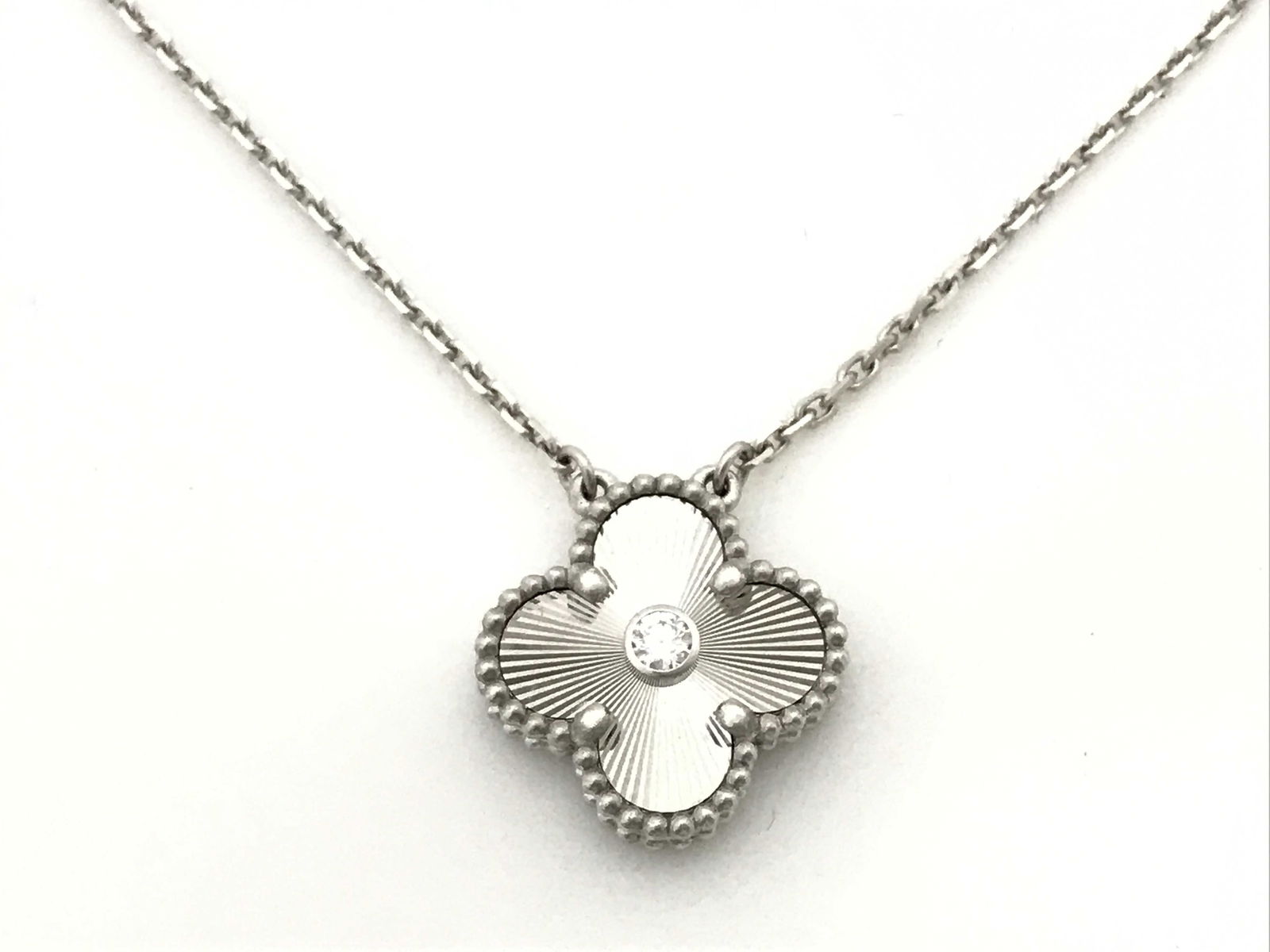 Van Cleef and Arpels Vintage Alhambra Holiday Edition 2020 Guilloche Diamond 18K White Gold Pendant: Elegant Van Cleef & Arpels Vintage Alhambra Holiday Edition 2020 pendant necklace crafted in 18K white gold, featuring a single iconic Alhambra motif with a finely executed guilloché engraved finish,