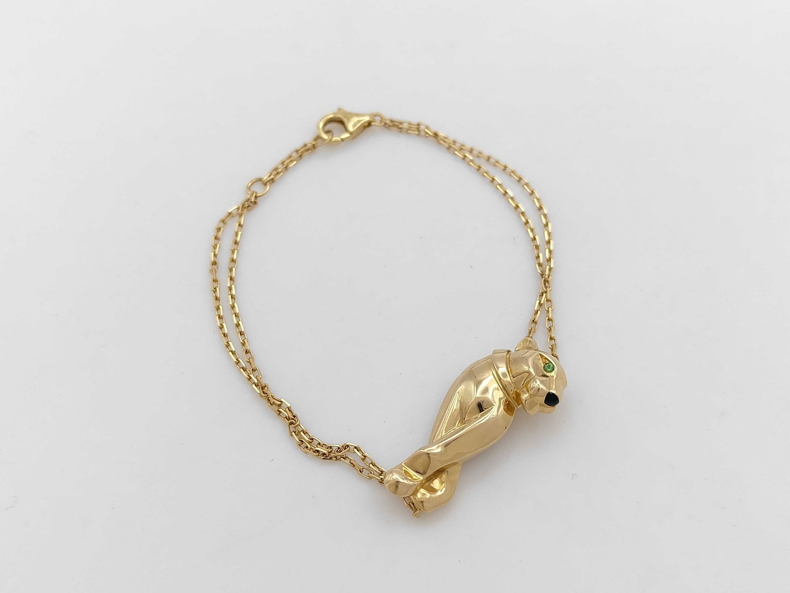 Cartier Panthere Yellow Gold Tsavorite Double Chain Bracelet: Elegant Cartier Panthere bracelet crafted in 18K yellow gold, featuring the maison’s iconic panther motif accented with vivid green tsavorite garnet eyes. The refined double chain design adds moveme