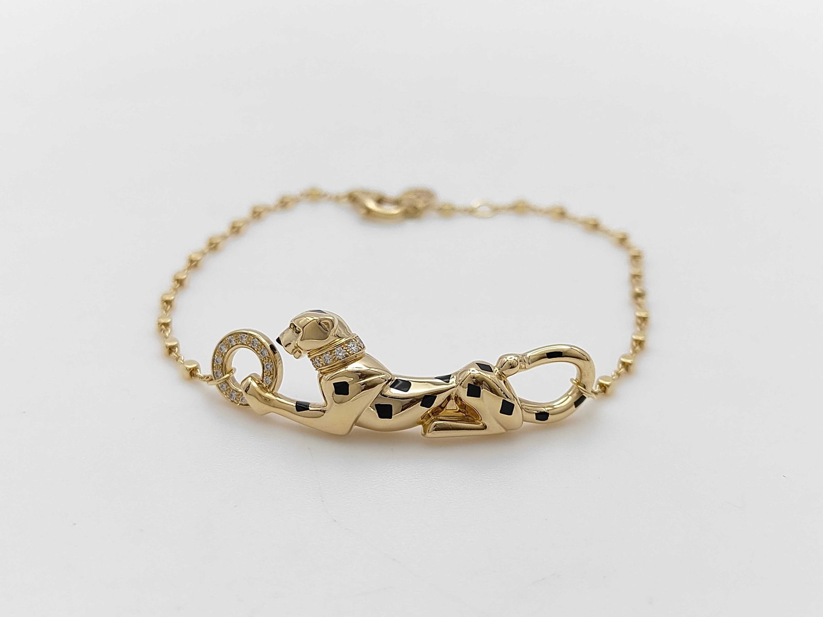 Cartier Panthere Tsavorite 18K Yellow Gold Chain Bracelet: Elegant Cartier Panthere bracelet crafted in 18K yellow gold, featuring the maison’s iconic panther motif accented with vivid green tsavorite garnets and refined diamond details. The sleek chain bra