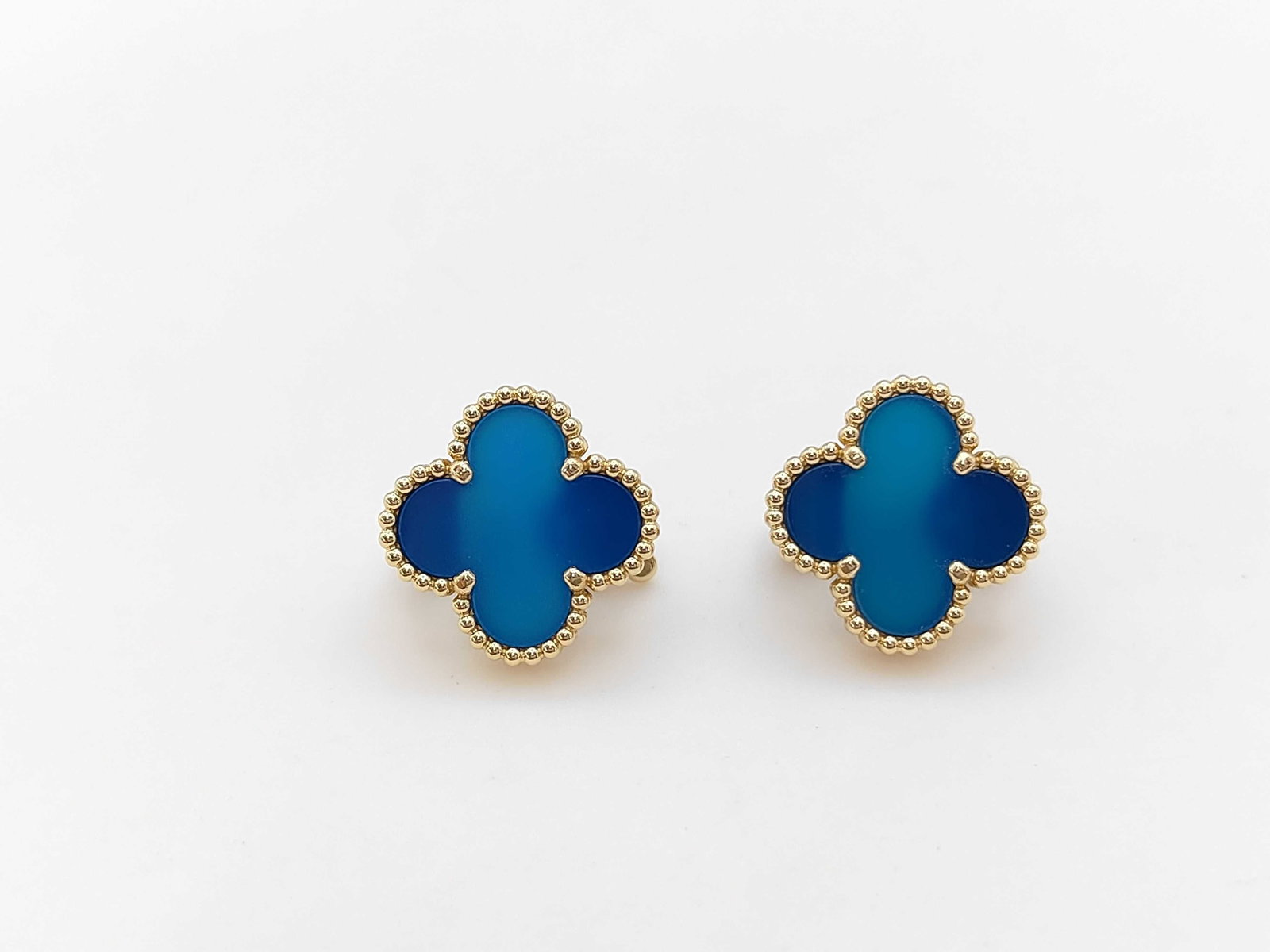 Van Cleef & Arpels Vintage Alhambra Blue Agate 18K Yellow Gold Earrings: Van Cleef & Arpels Vintage Alhambra earrings crafted in 18K yellow gold and accented with rich blue agate motifs. Featuring the maison’s iconic clover-inspired design, these earrings embody the time