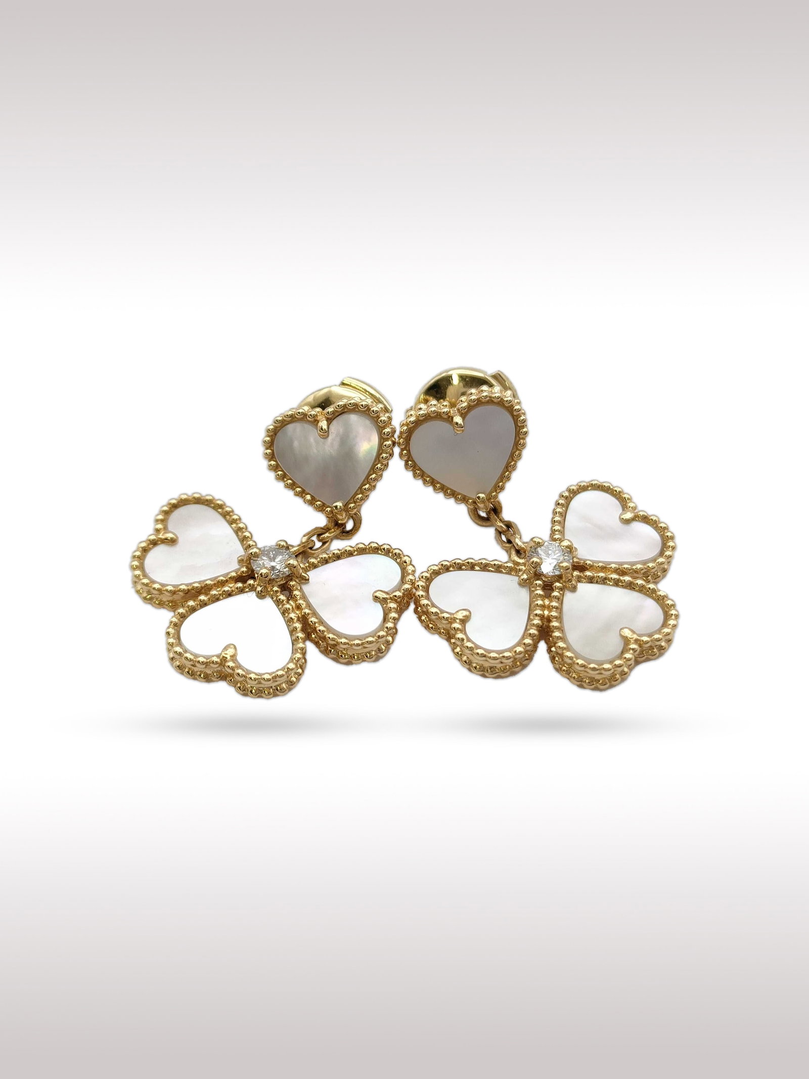 Van Cleef Arpels Sweet Alhambra Heart Mother of Pearl 18K Yellow Gold Earrings: Description: Elegant Van Cleef Arpels Sweet Alhambra heart earrings crafted in 18K yellow gold, featuring delicate heart shaped motifs set with luminous mother of pearl. The design is framed by the Ma